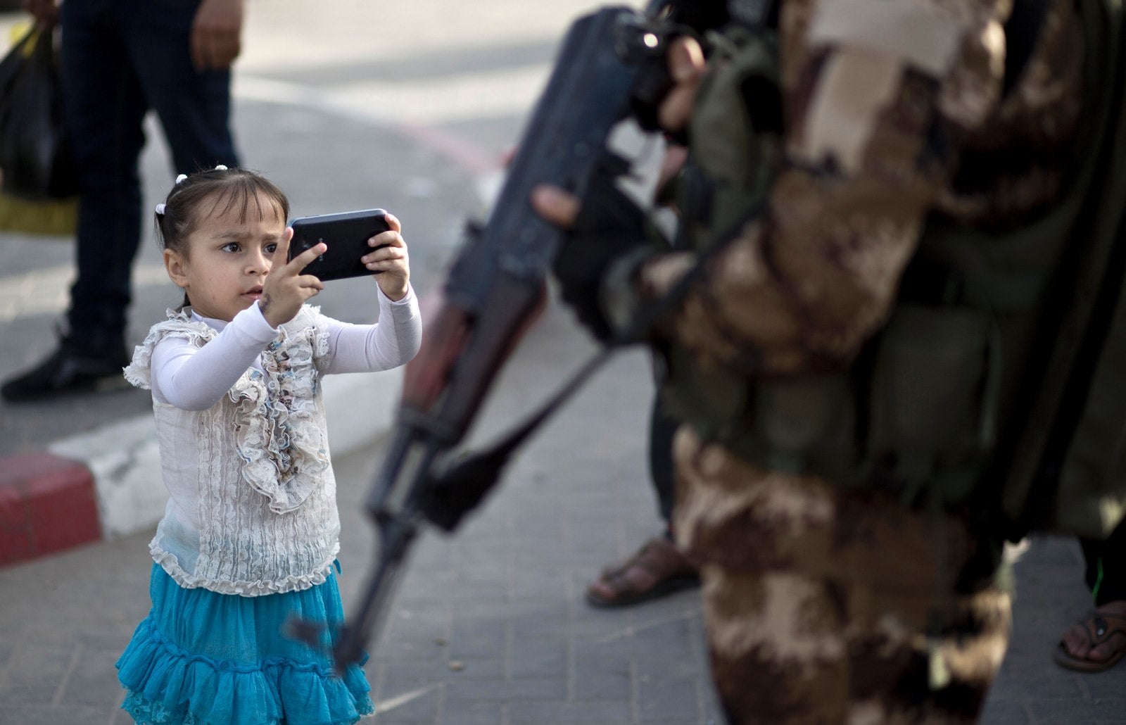 Una joven toma una foto de un miembro de las Brigadas Ezzedine al-Qassam, el brazo armado del movimiento islamista palestino Hamas, durante una reunión que marca el día del preso palestino en la ciudad de Gaza