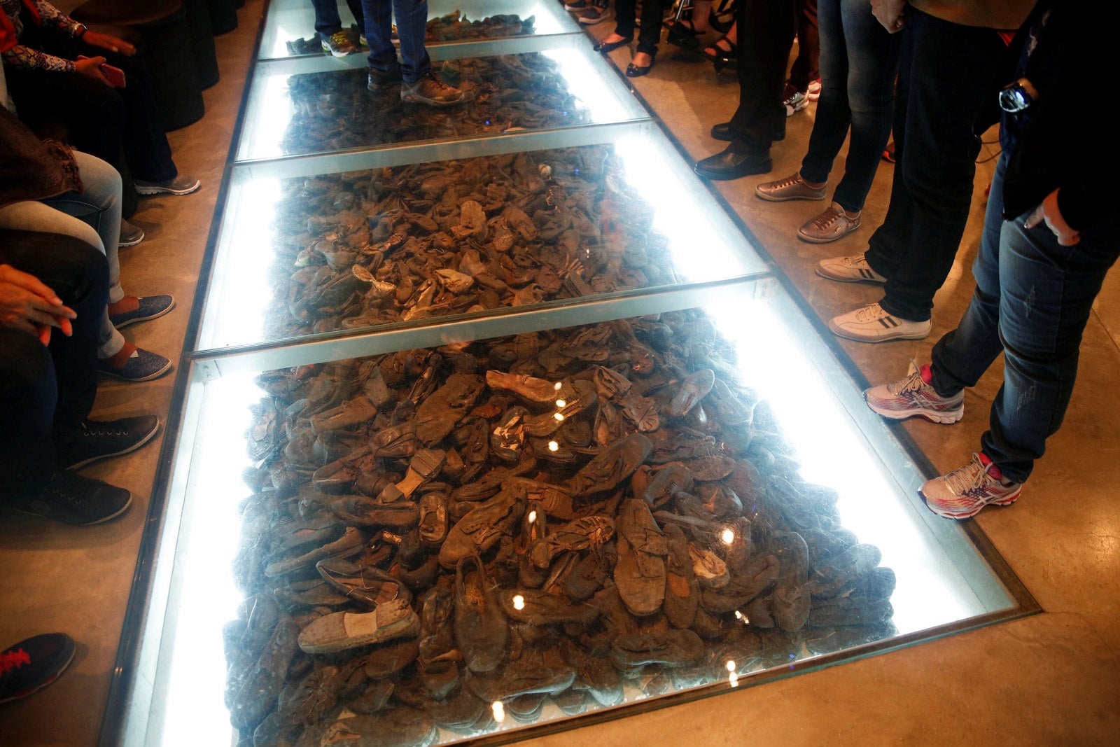 Los visitantes junto a una exposición que comprende de zapatos pertenecientes a las víctimas del Holocausto durante una visita al Museo de Historia del Holocausto de Yad Vashem en Jerusalem