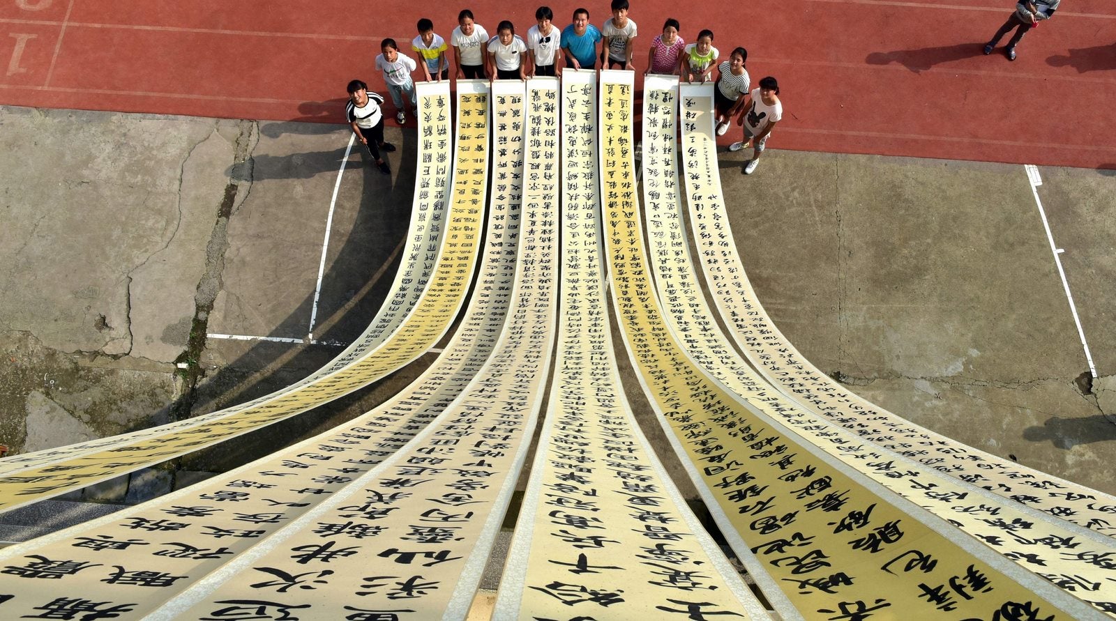 Estudiantes muestran rollos de caligrafía china llamada "Mo Yun" en una escuela primaria en Yiwu, provincia oriental china de Zhejiang.