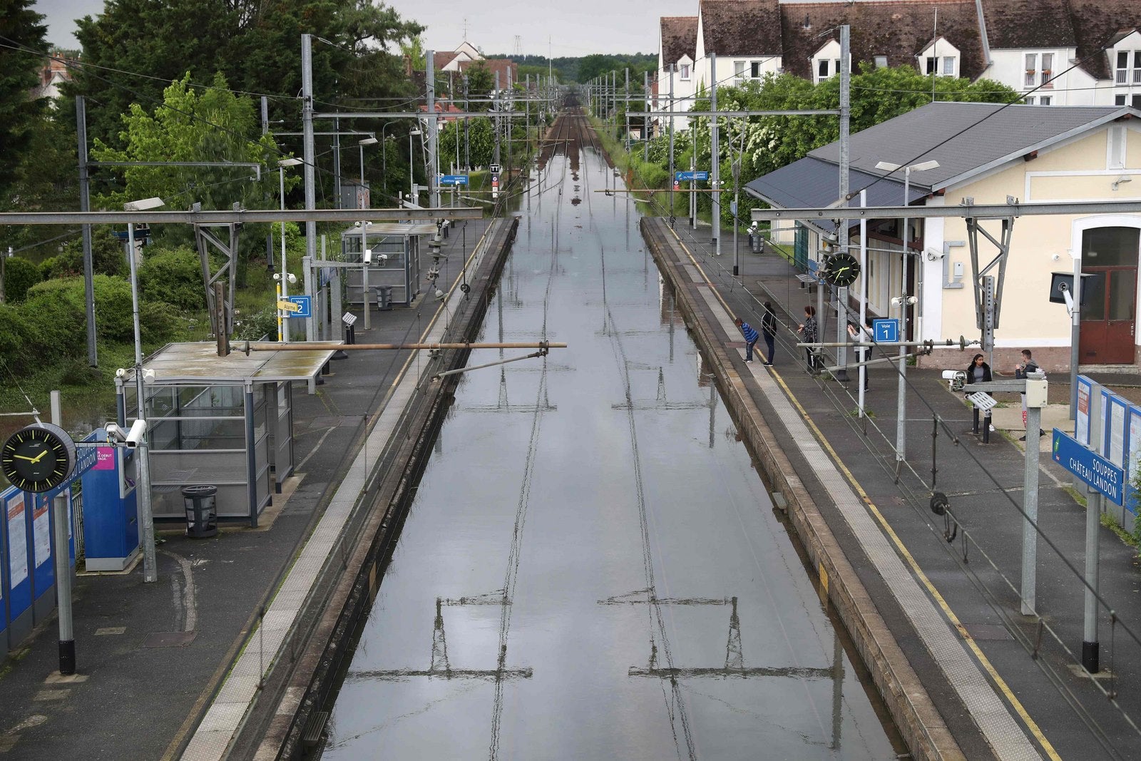 Gente viendo las vías del ferrocarril inundadas en Souppes-sur-Loing, al sureste de París.