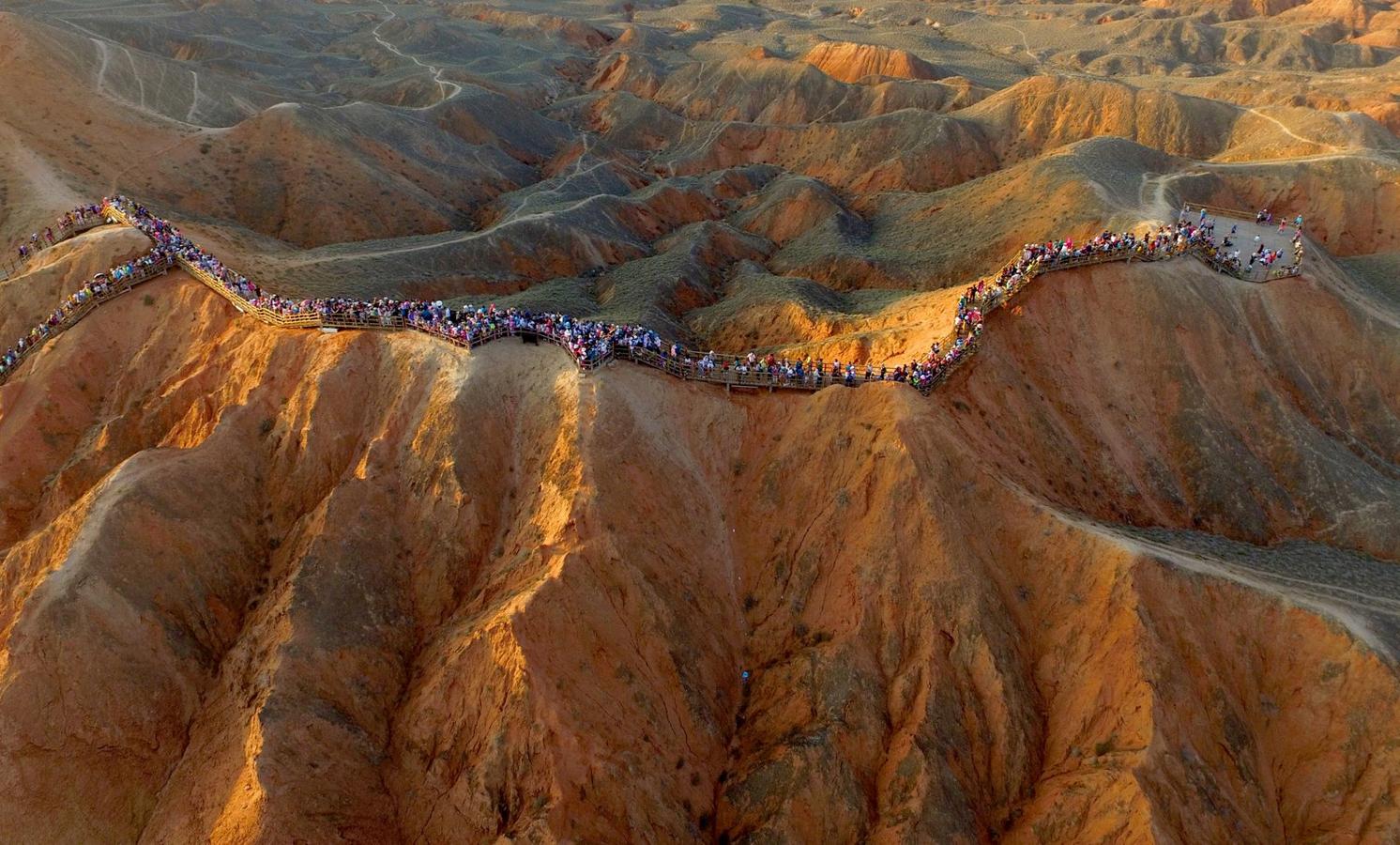 Una vista aérea muestra las personas que visitan un área de Danxia en forma de relieve de Zhangye, provincia de Gansu.