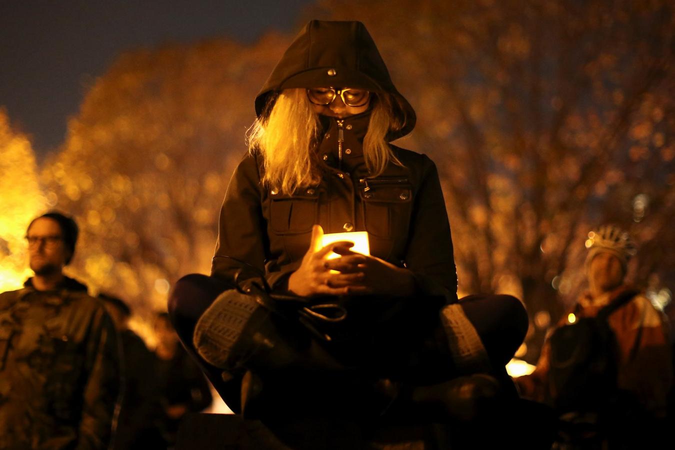 Una mujer sostiene una vela en una vigilia por las víctimas del incendio en el almacén en Oakland, California, EEUU.