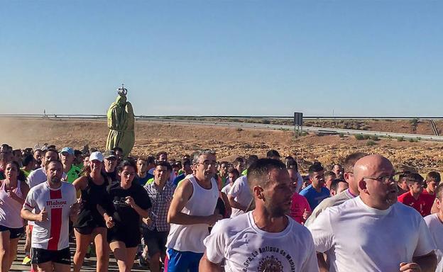 Los devotos corren con la imagen de la virgen de Manjavacas, envuelta para no sufrir daños, este pasado domingo. 