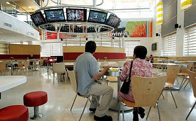 Dos clientes sentados en un restaurante de McDonald's.