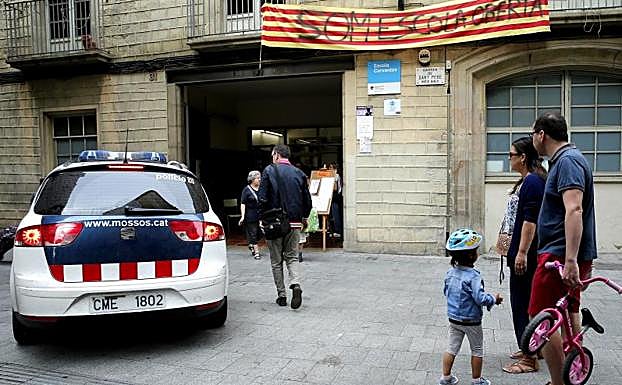 Un coche de los Mossos, frente a un colegio que permanece abierto.
