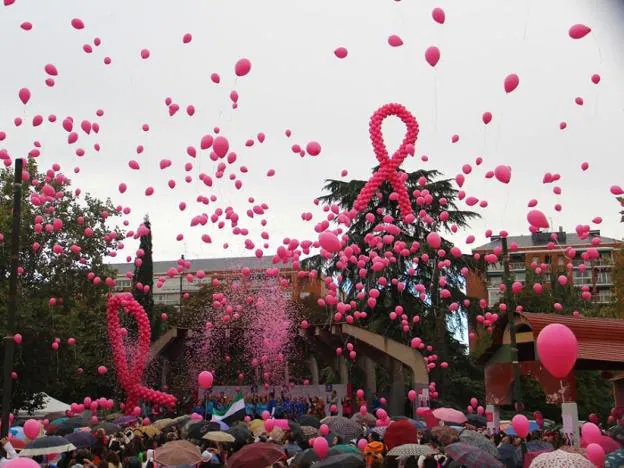 Lazos y globos rosas en una concentración contra el cáncer de mama.