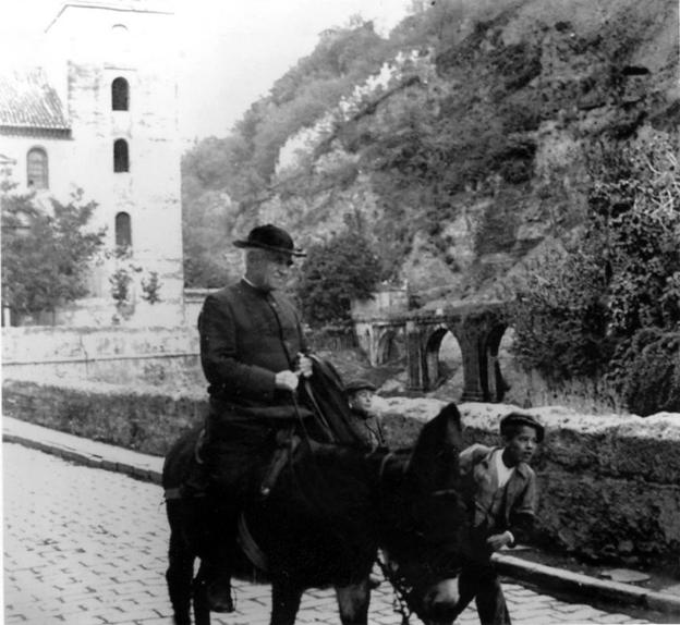 Un niño acompaña a Andrés Manjón, montado en burro, en la Carrera del Darro de Granada.