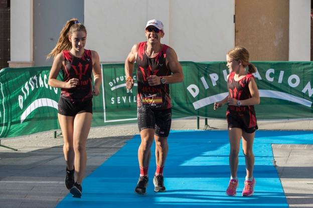José Antonio Padilla recorriendo los últimos metros de la prueba sevillana, acompañado de sus hijas para atravesar la línea de meta.