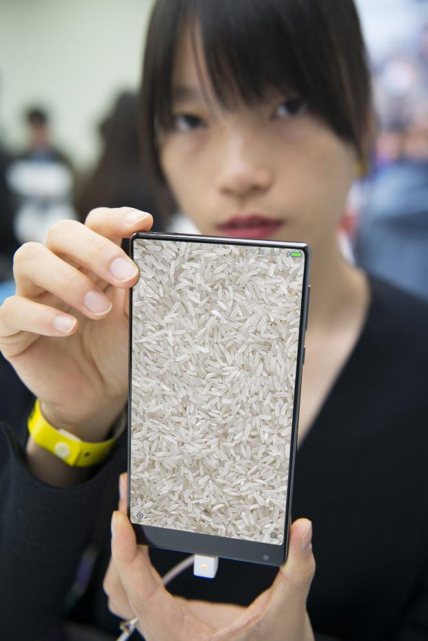 Al grano. Una joven muestra un terminal de Xiaomi, que en chino se traduce como arroz.