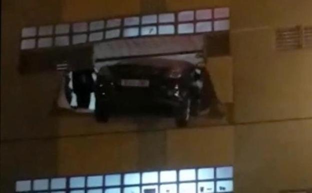 Una mujer atraviesa la pared de un aparcamiento con su coche