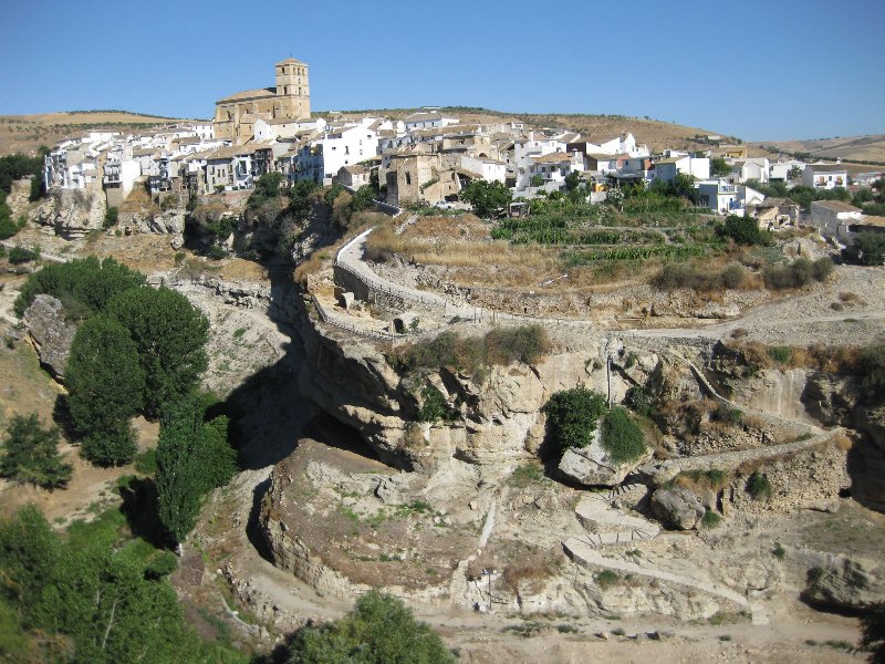 Alhama de Granada. Está situada a los pies del Parque Natural Sierras de Tejeda, Almijara y Alhama, en la parte occidental de la comarca de Alhama. Sus baños termales árabes tienen fama mundial y están asentados sobre restos de los baños romanos, de los que procede su propio nombre, al-Hama, que significa "el baño" . Es el destino idóneo para los amantes del senderismo por sus imponentes barrancos que se encuentran en la parte alta de la localidad, catalogados como Monumento Natural de Andalucía de carácter Geológico. También el casco antiguo de la localidad fue declarado Conjunto Histórico-Artístico. En él destacan la Iglesia Mayor de la Encarnación, el Hospital de la Reina, la Casa de la Inquisición y la fuente popularmente conocida como Caño Wamba.