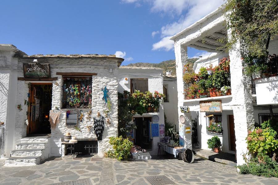 Pampaneira. Este pueblo de la Alpujarra está situado en el barranco de Poqueira y junto a Bubión y Capileira es Conjunto Histórico Artístico que ha mantenido el aspecto berebere en la arquitectura de sus casas, con tejados de pizarra y sus calles estrechas por las que discurren acequias. El casco urbano está situado en la vertiente Sur de Sierra Nevada en el "Barranco de Poqueira", en las cumbres del Mulhacén y Veleta y cuenta con espectaculares vistas y senderos que bien merecen una caminata. El visitante además encontrará, a muy buen precio, productos artesanales como las alfombras (jarapas), la cerámica y el esparto.