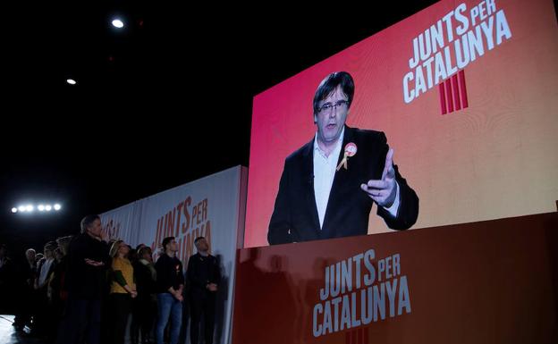 Seguidores de Junts per Catalunya siguen la videoconferencia de Puigdemont. 