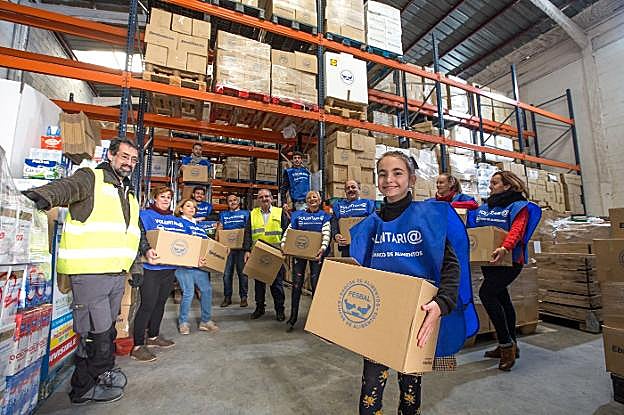 Una veintena de voluntarios se afanaban ayer sábado por la mañana en seleccionar y apilar las miles de cajas de comida en las naves que el Banco de Alimentos dispone en la Carretera de Córdoba.