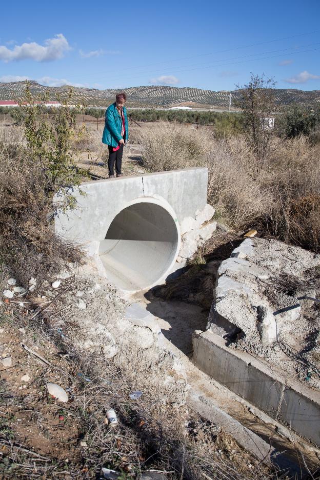 La alcaldesa de Valderrubio muestra la diferencia de calibre entre canalización procedente del arroyo Hondo de Tobares y acequia del pueblo.