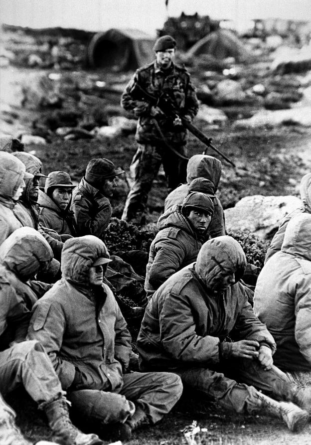 Un soldado custodia a prisioneros argentinos durante la guerra de las Malvinas. 