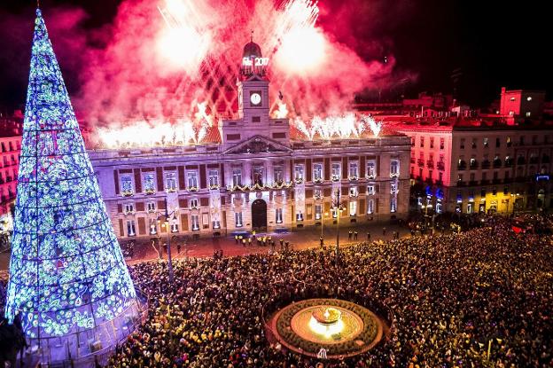 Miles de personas se dan cita cada noche de fin de año ante el emblemático reloj madrileño. :MADRID