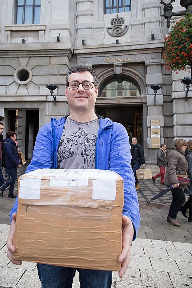 José Baena muestra el paquete de los 317 días ante la oficina postal de Puerta Real.