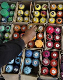 Imagen secundaria 2 - 1. Badi Coloreando ante uno de sus murales, en Ventas de Huelma. / 2. Un surtido de botes de colores.