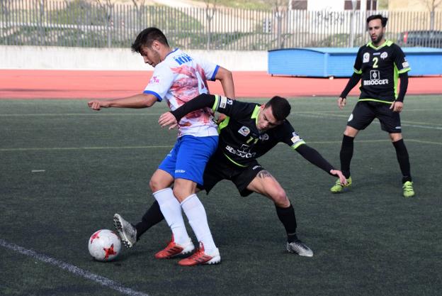 Álex Romero trata de dejar atrás a un jugador de El Palo.