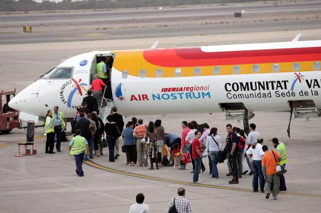 Pasajeros suben a un avión de Air Nostrum en El Alquián. 