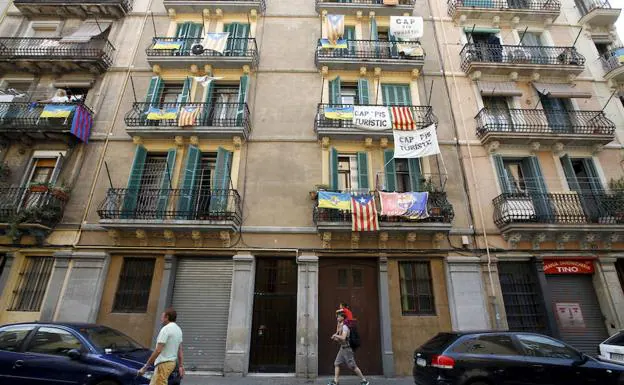 Varios vecinos de Barcelona cuelgan pancartas contra los alquileres turísticos. 