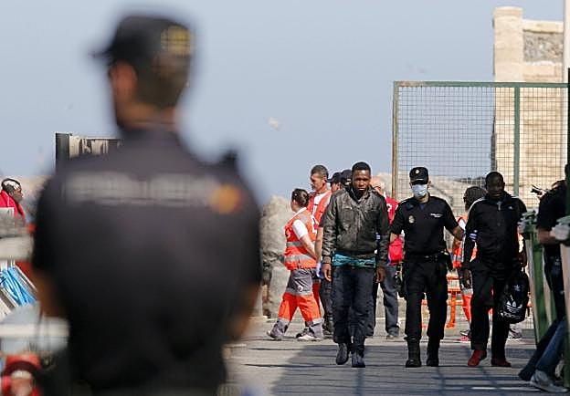 Agentes recepcionan la llegada de una patera al puerto almeriense. 