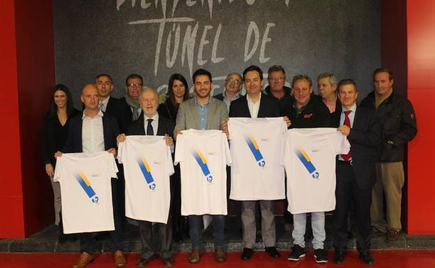 Los representantes de las instituciones implicadas posan con la camiseta de la carrera.