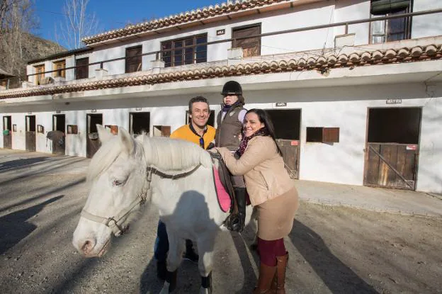 Triana posa a lomos de Dulcinea y flanqueada por sus padres.