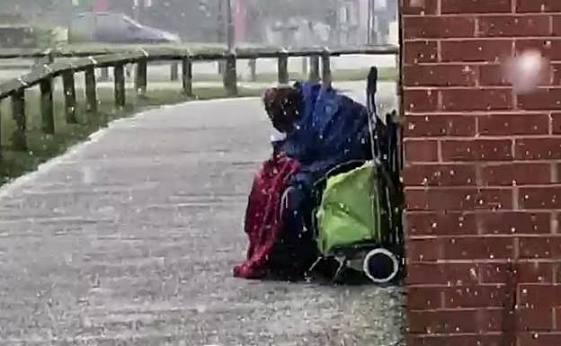 La foto de un anciano indigente hecho un ovillo bajo la nieve agita conciencias