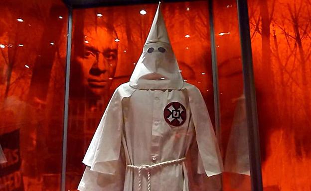 Imagen de un afroamericano detrás de la indumentaria de un miembro del Ku Klus Klan, una de las instalaciones que componen la exposición de National Geographic: 'Americano yo soy; la huella africana' . 