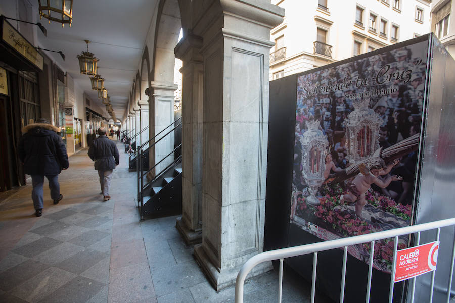 El Ayuntamiento inaugura una muestra de carteles con las fotos de Semana Santa de 2017 para embellecer la céntrica calle 'tapando' la parte trasera de las gradas de la carrera oficial.