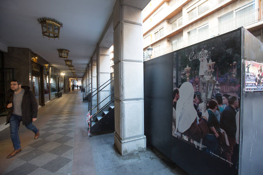 El Ayuntamiento inaugura una muestra de carteles con las fotos de Semana Santa de 2017 para embellecer la céntrica calle 'tapando' la parte trasera de las gradas de la carrera oficial.