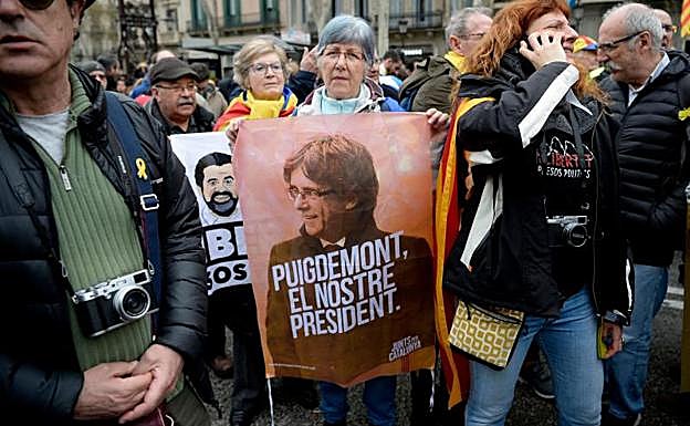 Una mujer muestra un cartel en apoyo a Puigdemont en Barcelona. 