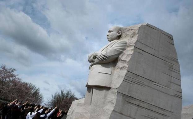 Un grupo de personas señala la estatua en honor a Martin Luther King en Washington.