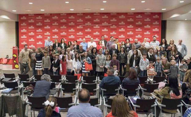 Foto de familia de los premiados en el certamen literario con los representantes de la cooperativa. 