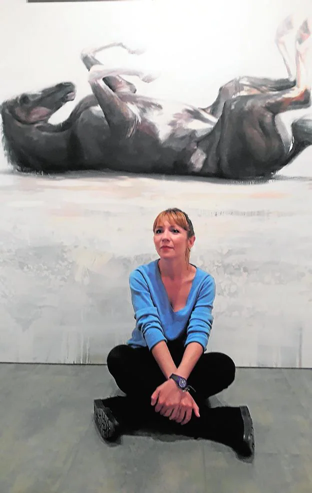 La artista Susana Ragel, con uno de los lienzos al fondo.