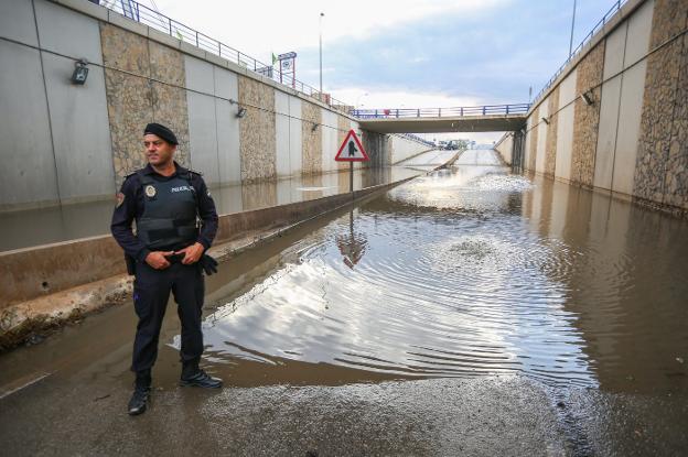 Un agente de la Policía Local impide el paso en el subterráneo de la avenida de Andalucía. 