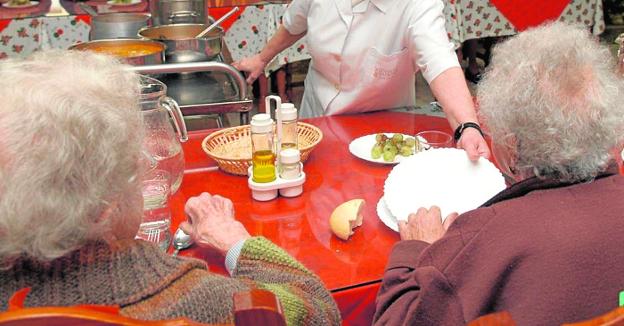 Dos ancianas comen en una residencia de ancianos.