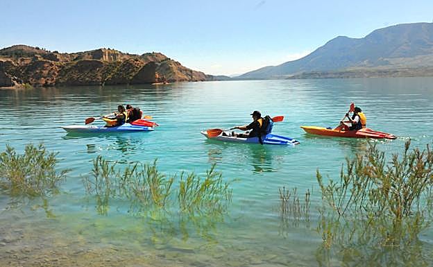 Piragüistas en el pantano del Negratín con una gran cantidad de agua embalsada.