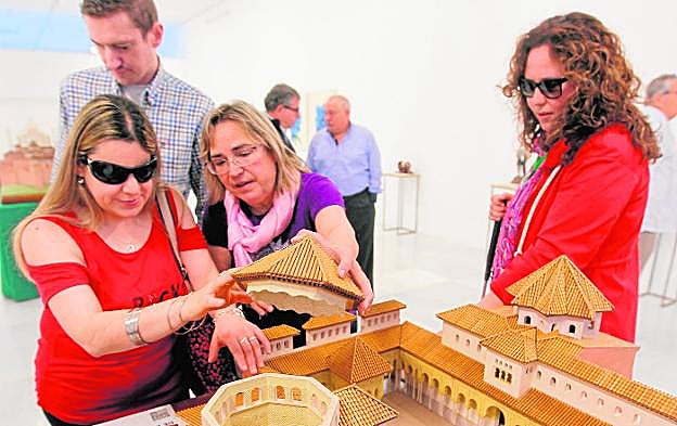 Un persona con deficiencia visual toca la maqueta del Patio de los Leones.