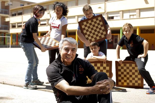 Don Enrique, el profesor, ante un grupo de alumnos con tableros de ajedrez en la escuela Marcos Frechín de Zaragoza. :: fabián simón