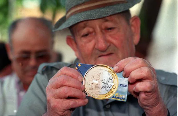 PIONEROS. Un vecino de Churriana abre uno de los paquetes de euros de prueba que se repartieron entre el 30 de septiembre y el 3 de octubre de 1998. :: ñito salas. archivo