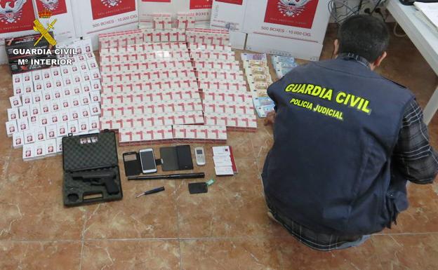 Un agente inspecciona los objetos decomisados en una operación contra el contrabando de tabaco.