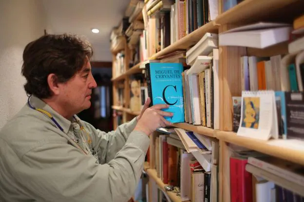 El poeta Luis García Montero, nuevo director del Instituto Cervantes, fotografiado con un libro sobre el autor del Quijote en la biblioteca de su casa en Granada.