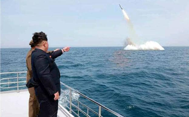 Kim Jong-un señala un misil. 