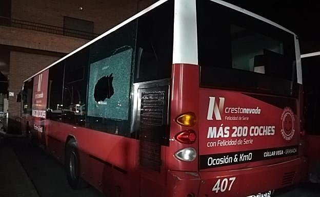 Uno de los autobuses afectados y con una ventana rota.