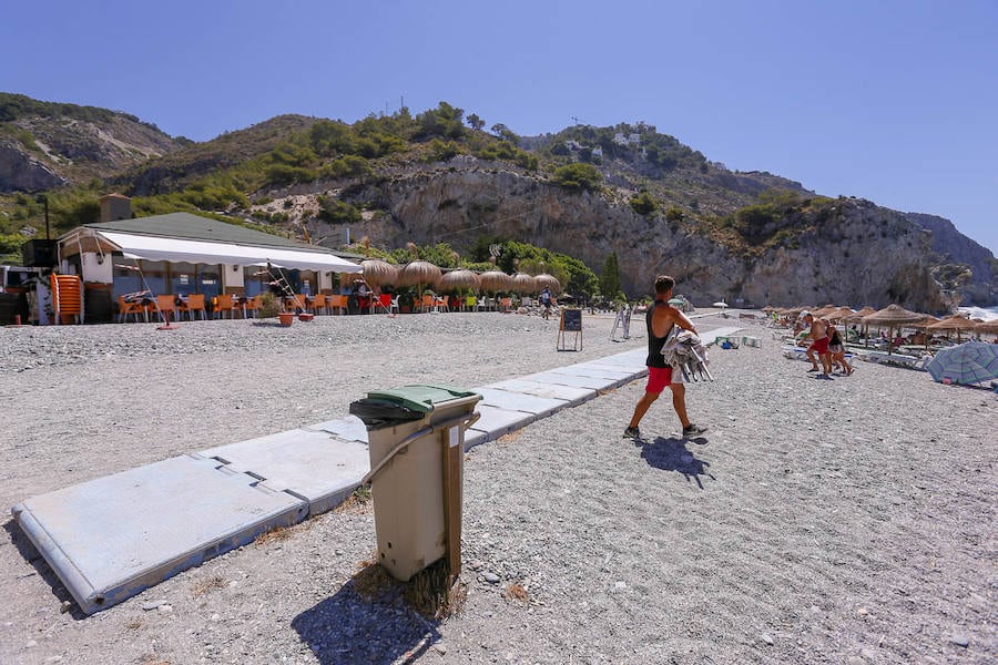 Vista de chiringuitos a pie de playa, junto a papeleras y pasarelas de acceso.