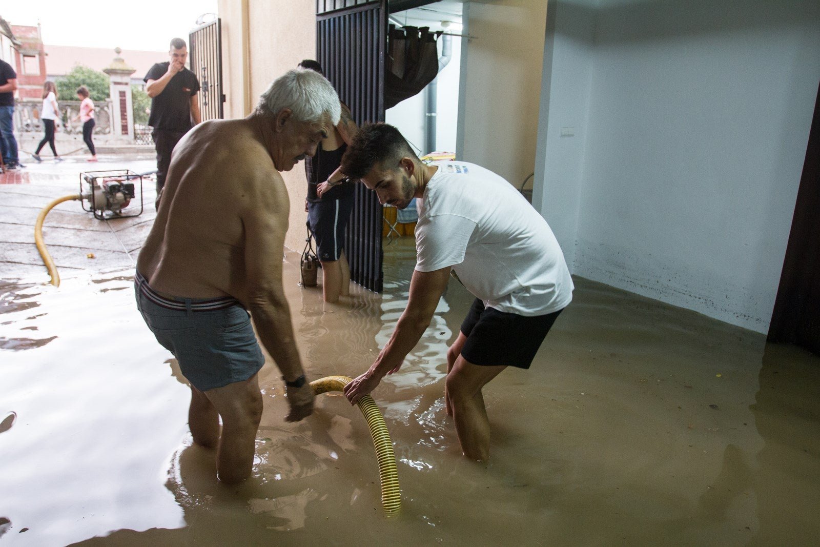 Los vecinos de algunas zonas del municipio se han visto obligados a achicar el agua que ha entrado en sus viviendas