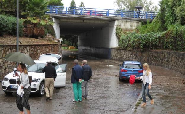 Varias personas fuera de sus coches sin poder circular en la localidad malagueña de Marbella . 